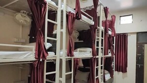 A dormitory room with bunk beds, a ceiling fan, and a window. - 5 Star Dormitory  (Jabalpur)