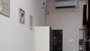 A room with a bed, a wardrobe, a refrigerator, and a small kitchen area with a gas stove. - 5 Star Dormitory  (Jabalpur)