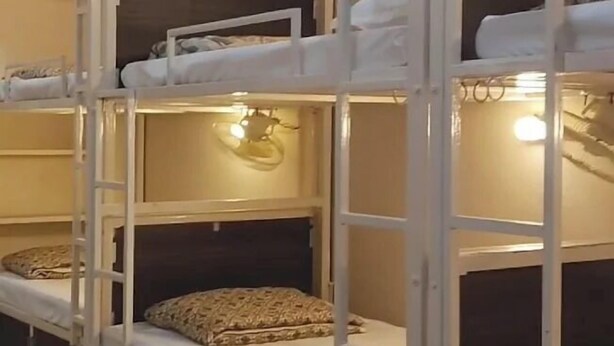 A bunk bed room with multiple beds, each with a pillow and a blanket. - 5 Star Dormitory  (Jabalpur)