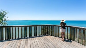 A wooden deck with a railing overlooking a body of water. - The Point Arkwright Bungalow (Point Arkwright)