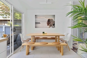 Ein moderner Essbereich mit Holztisch und Stühlen, einer Bank und einem gerahmten Bild an der Wand.