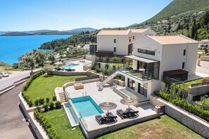 A modern villa with a pool, outdoor seating, and a view of the sea. - Ionian Hospitality Resort (Lefkada)