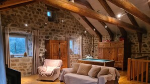 A cozy room with a pool table, a sofa, and a wooden cabinet. - La ferme des Farios 4 pers (Tence)