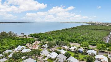 A residential area with houses, a road, and a body of water in the background.
