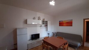 A compact living space with a kitchenette, a dining area, and a bed.