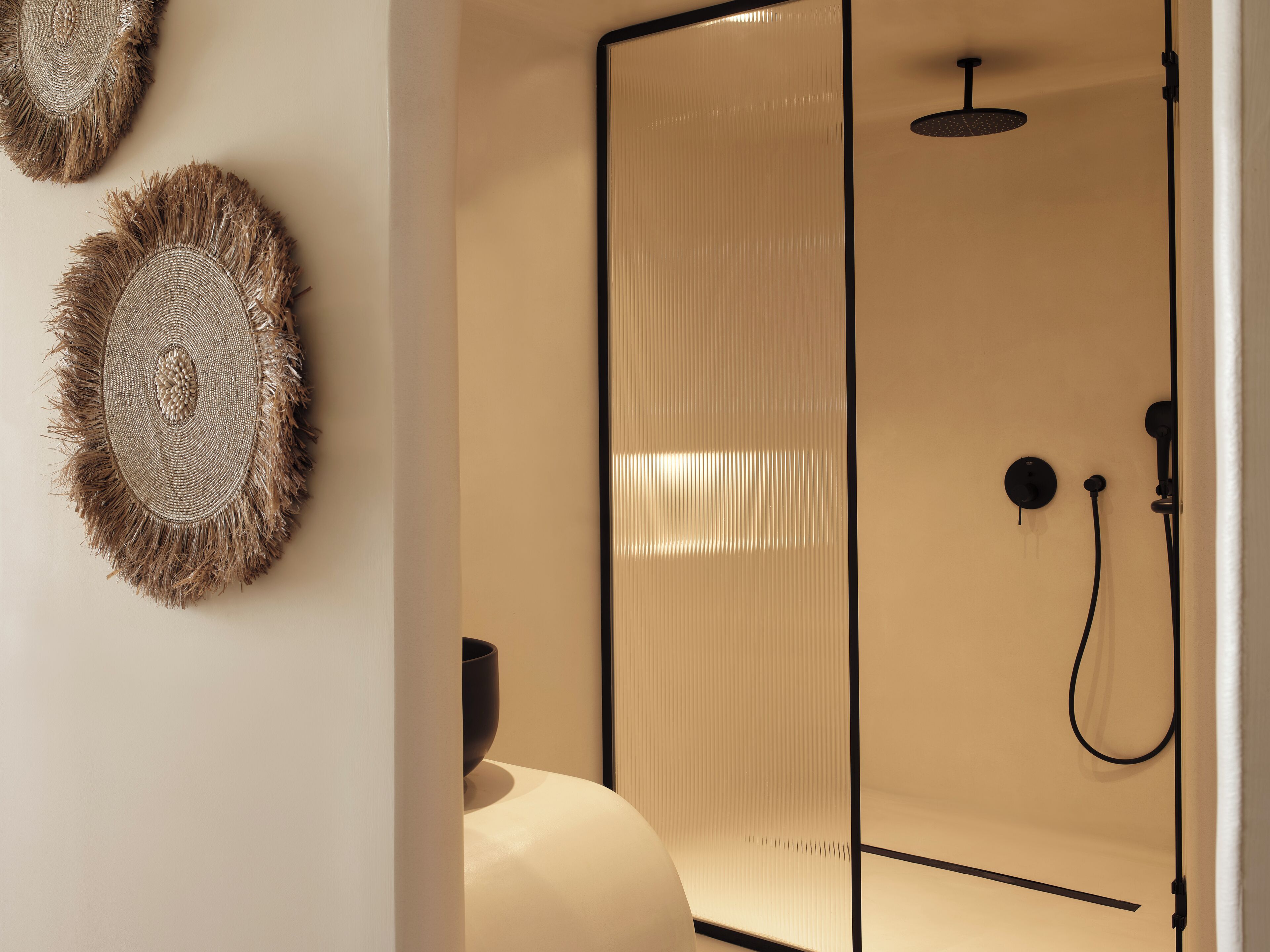 Un baño moderno con cabina de ducha de vidrio, un perchero y detalles decorativos en la pared.