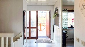 A hallway leading to a door with a view of a garden and a building outside. - 4 Star Holiday Home in Ljusne (Ljusne)