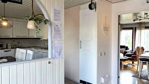 A modern kitchen with white cabinetry, a welcome sign, and a clock on the wall. - 4 Star Holiday Home in Ljusne (Ljusne)
