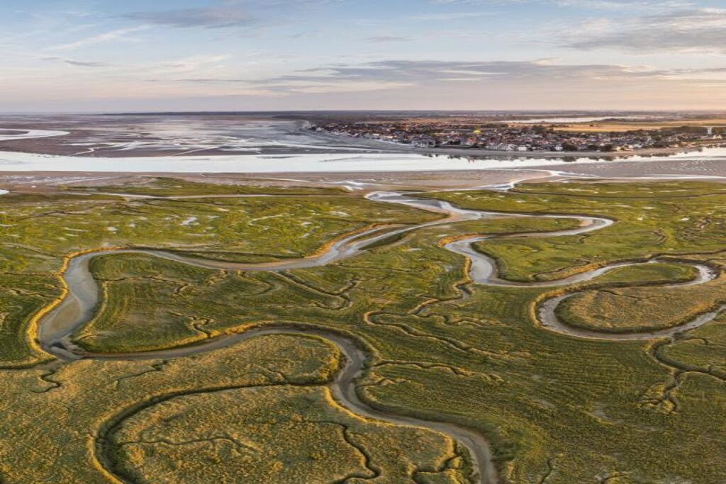 An aerial view of a coastal landscape with winding roads and a small settlement.