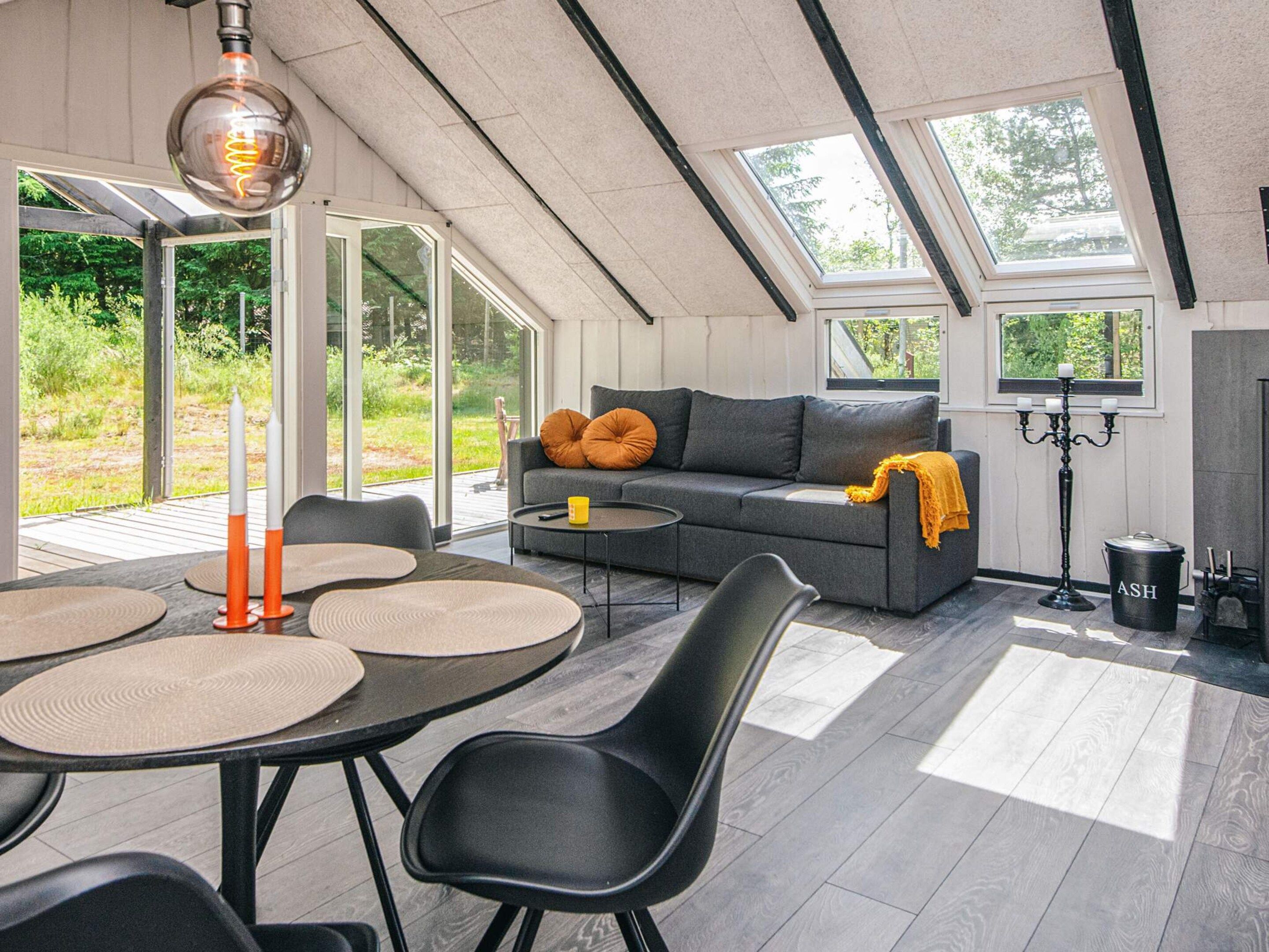 Un interior moderno con comedor, sofá y chimenea.