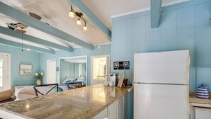 A kitchen with a granite countertop, white cabinets, a white refrigerator, and a blue wall. - 4 Mi to Downtown Chattanooga: Vibrant Studio (Chattanooga)