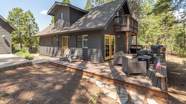 A cabin with a deck, outdoor seating, and a grill area. - Boujee Bear Lodge- BLS Access (Arnold)