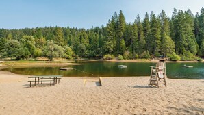 A beach with picnic tables and a lifeguard stand. - Boujee Bear Lodge- BLS Access (Arnold)