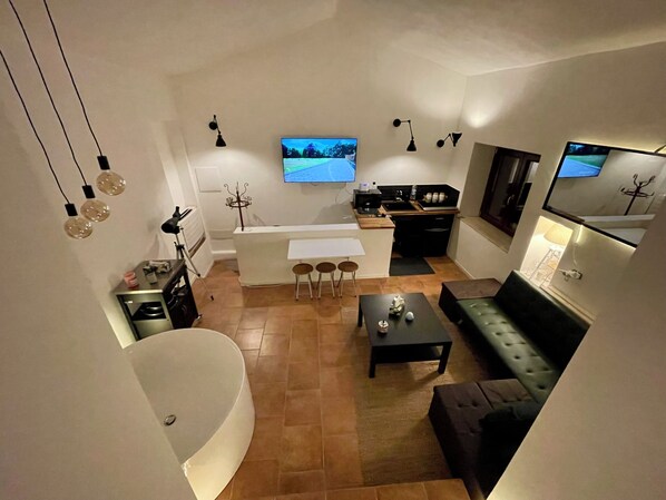 Un espacio habitable compacto con cocina, comedor y un amplio ventanal.
