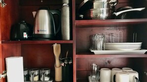 Eine Küche mit Kaffeemaschine, Wasserkocher und Geschirr auf der Arbeitsfläche.