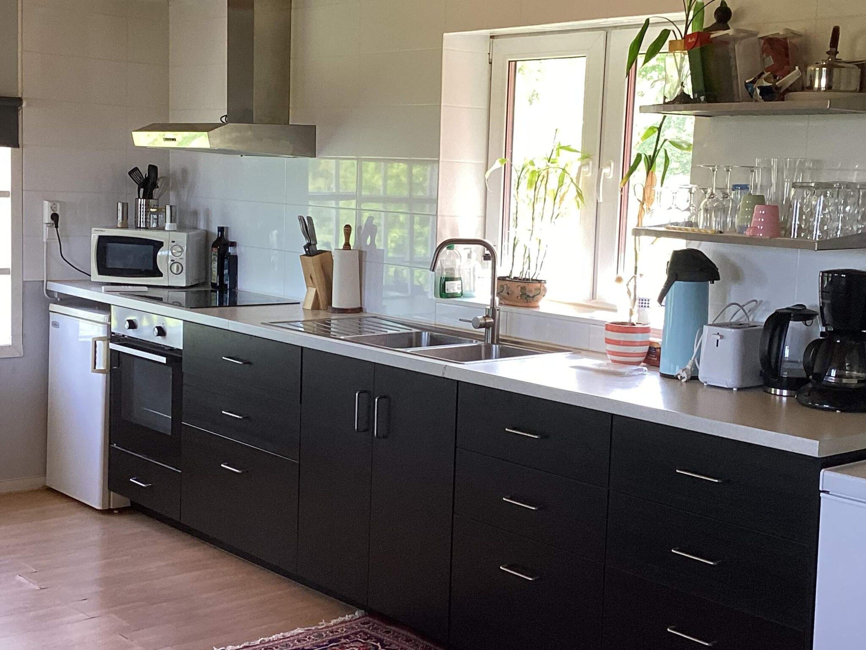 A modern kitchen with a microwave, oven, sink, and various appliances.