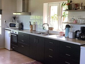 A modern kitchen with a microwave, oven, sink, and various appliances. - 4 Person Holiday Home in Ullared (Ullared)