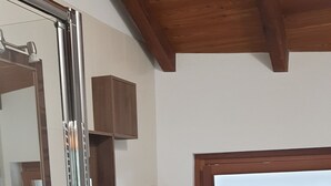 Un baño moderno con cabina de ducha de vidrio, un lavamanos blanco, un inodoro y una lavadora.