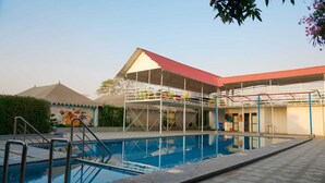 Una piscina con zona cubierta y un mural.