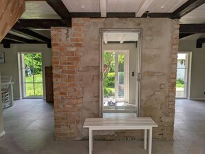 Une pièce avec un mur en briques, une porte blanche et une table blanche.