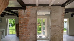 A room with exposed brick walls, a white door, and a white bench. - 5 Star Holiday Home in Hammenhog (Hammenhög)