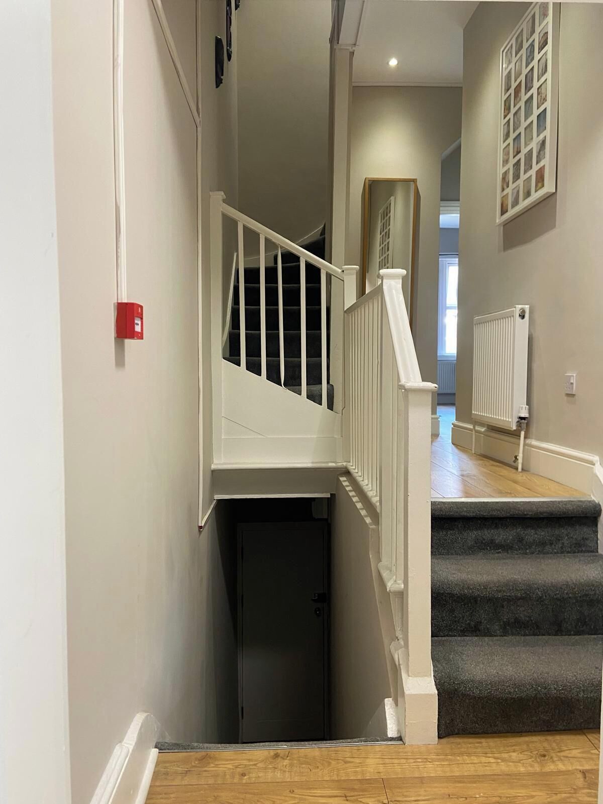 Eine Treppe mit weißen Geländern führt zu einem dunklen Teppichboden.