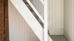 A white wooden staircase in a room with white paneled walls and a wooden floor. - 4 Star Holiday Home in Sandhem (Mullsjö)