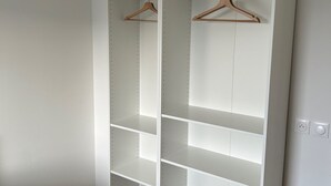A white walk-in closet with multiple shelves and wooden hangers. - AZUR Rated 3 stars (Camiers)