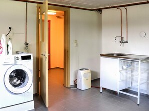 A laundry area with a washing machine, a dryer, and a sink with a metal rack.