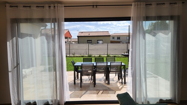 A room with a sliding glass door leading to an outdoor patio with a table and chairs. - Maison Noé ( New Villa ) Spacious near the center Fully air-conditioned (Ruoms)