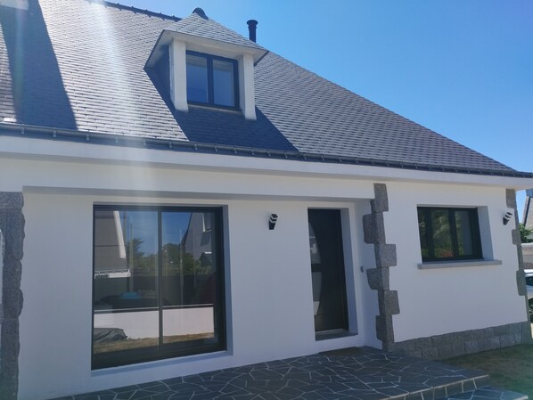 A modern house with a sloped roof, large windows, and a stone foundation. - House in the center of Quiberon, within walking distance of the beach (Quiberon)