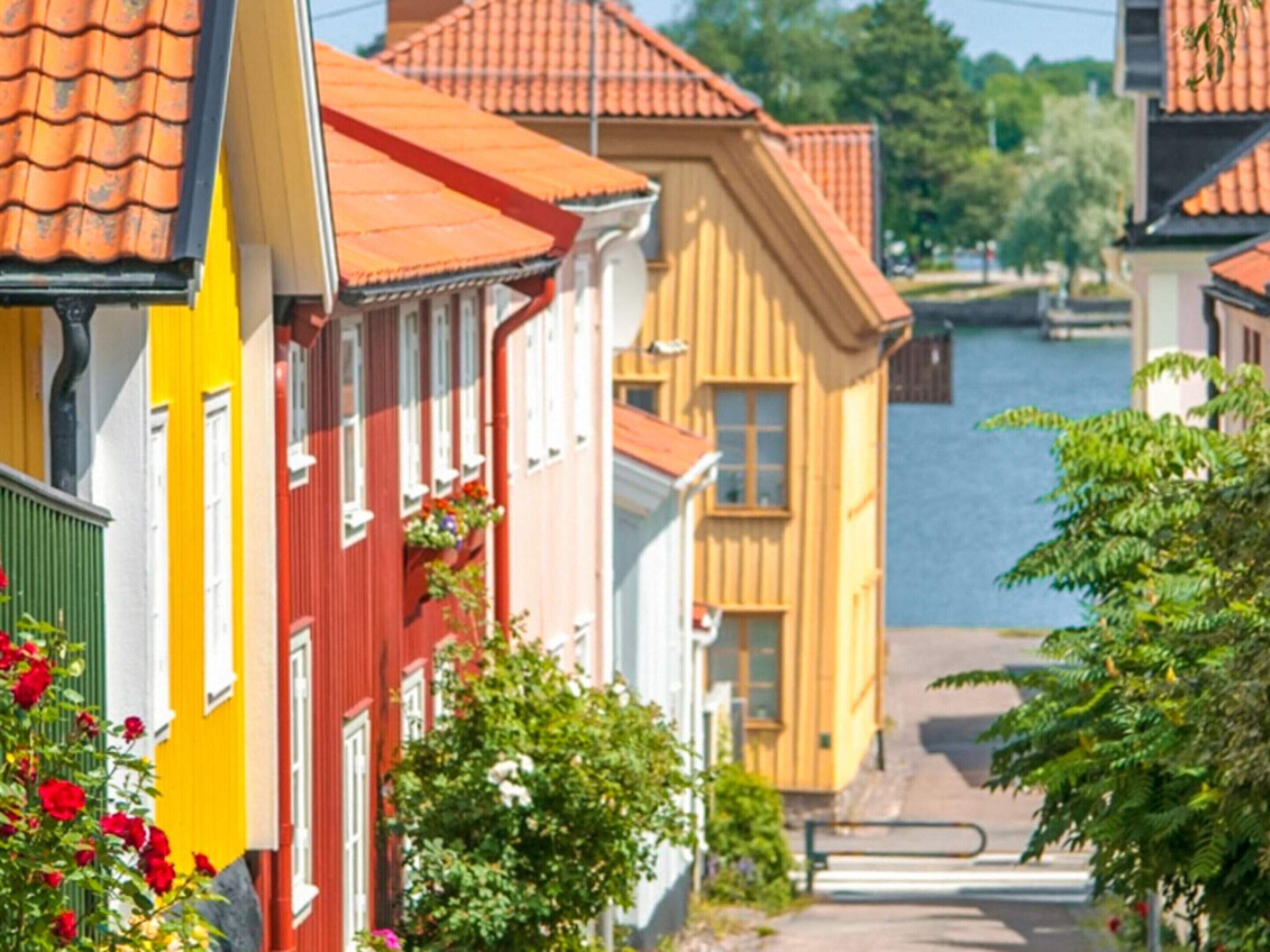 A row of colorful buildings with a river in the background.