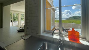 A kitchen with a large window overlooking a balcony and a scenic view. - 5 Star Holiday Home in Askeron (Hjaelteby)