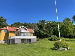 A yellow house with a red roof, a balcony, and a garage. - 5 Star Holiday Home in Askeron (Hjaelteby)