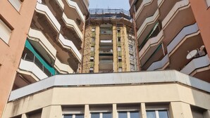 A multi-story building with a central atrium, large windows, and a ground-level entrance with a glass door.