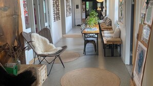 Un interior moderno con comedor, sillas de mimbre y una mesa larga.
