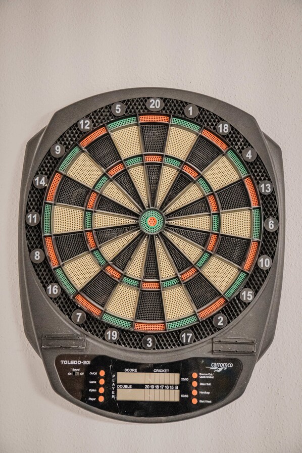 Un tablero de dardos con una tabla de puntuación y opciones de puntuación electrónica.