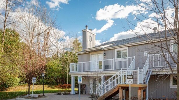 A two-story building with a covered porch and a staircase leading to the upper level. - The Alpine - Central Collingwood Condo (Collingwood)