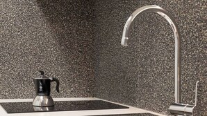A modern kitchen with a stainless steel sink, a black coffee maker, and a speckled backsplash. - Trieste Chic Studio Historic Elegance (Trieste)