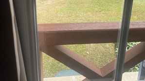 A view through a window of a grassy outdoor area with a blue fence and a playground. - House 6 persons.2 bedrooms, 1 living room (Monflanquin)