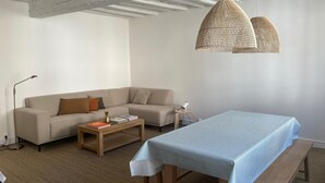 Una sala de estar moderna con un sofá, una mesa de centro y una mesa de comedor con un banco.