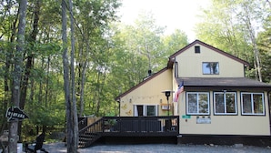 A lodge with a wooden deck, a flag, and a sign indicating 'Nirvana' and '253'.