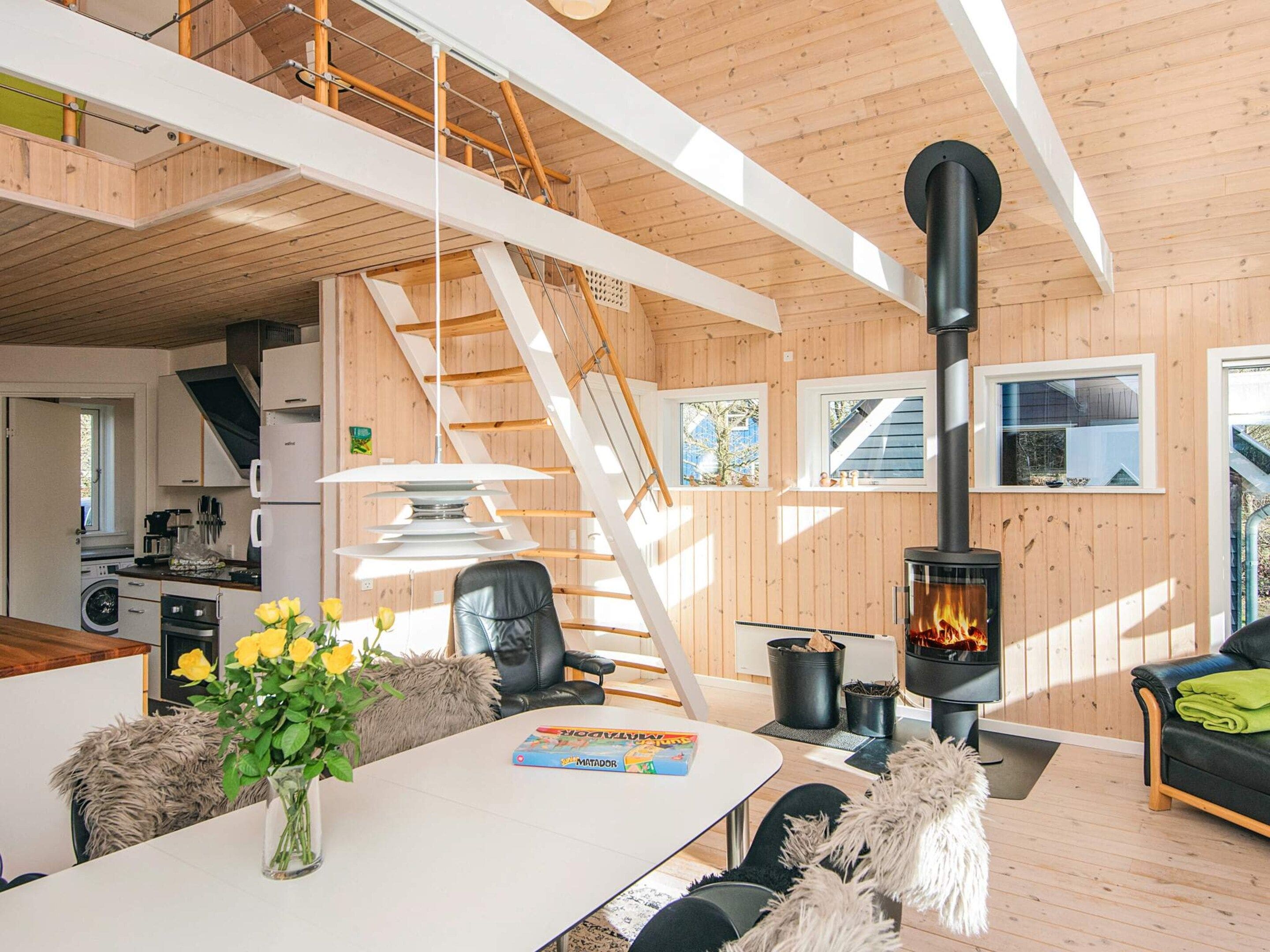 A modern interior with a kitchen, dining area, and a fireplace.