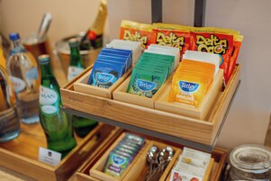 Eine Holztischplatte mit Tetley-Teebeuteln, einer Wasserflasche und einem Gewürzglas.