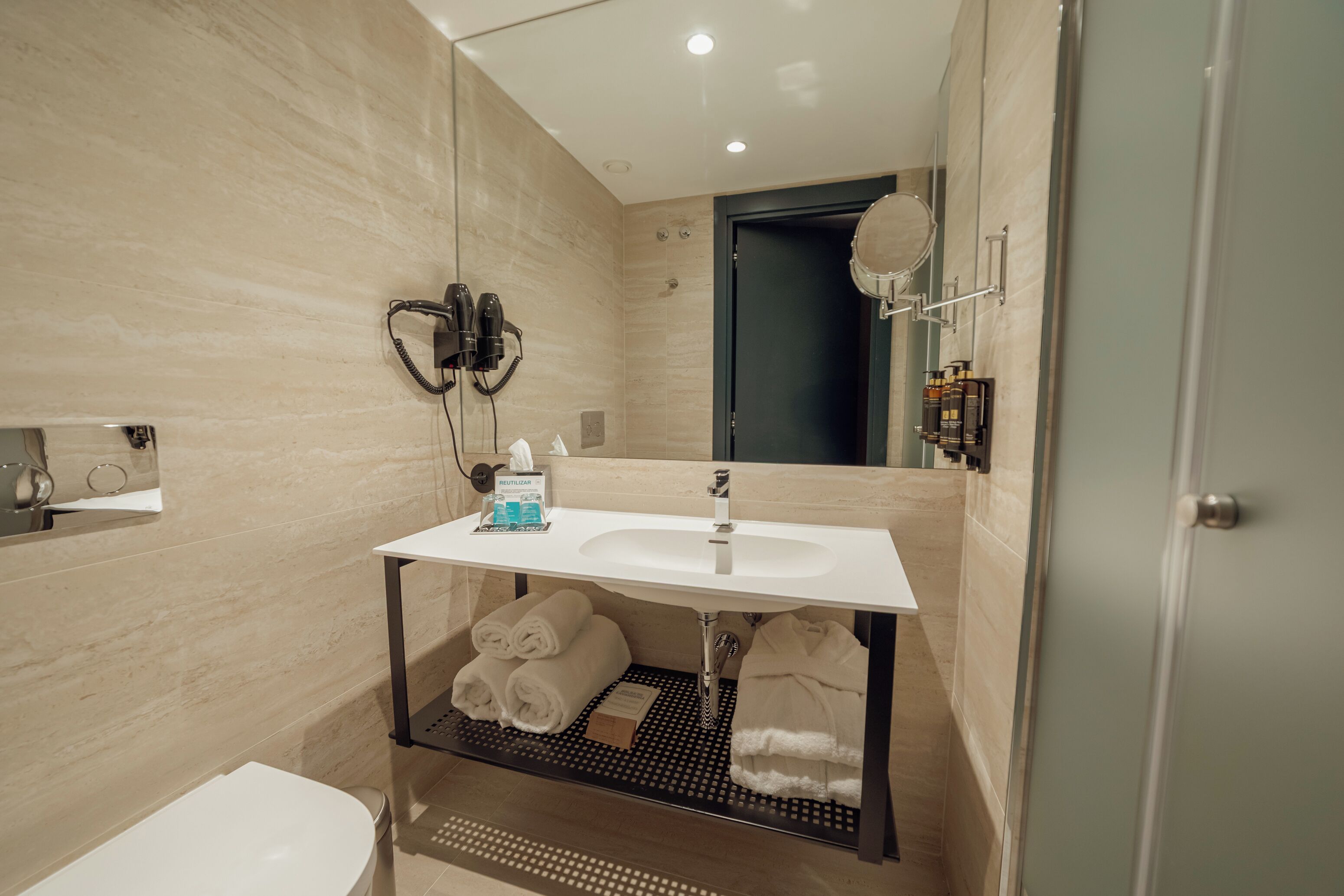 Ein modernes Badezimmer mit Waschbecken, Handtuchhalter und Spiegel.