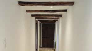 A hallway with wooden flooring and exposed beams on the ceiling. - Authentic Aubrac farmhouse with Jacuzzi. A change of scenery guaranteed! (Montpeyroux)
