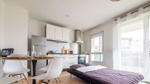 Eine moderne Wohnung mit Küche, Essbereich und einem Bett.