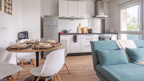 Eine moderne Küche mit weißen Schränken, einem eingebauten Backofen und einem Fenster, das für natürliches Licht sorgt.
