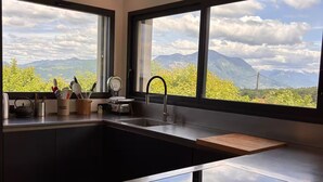 Une cuisine moderne dotée d’une grande fenêtre, d’un évier et de divers ustensiles.