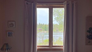 A bedroom with a large window, a bed, and a lamp. - 4 Star Holiday Home in Vaddo (Väddö)